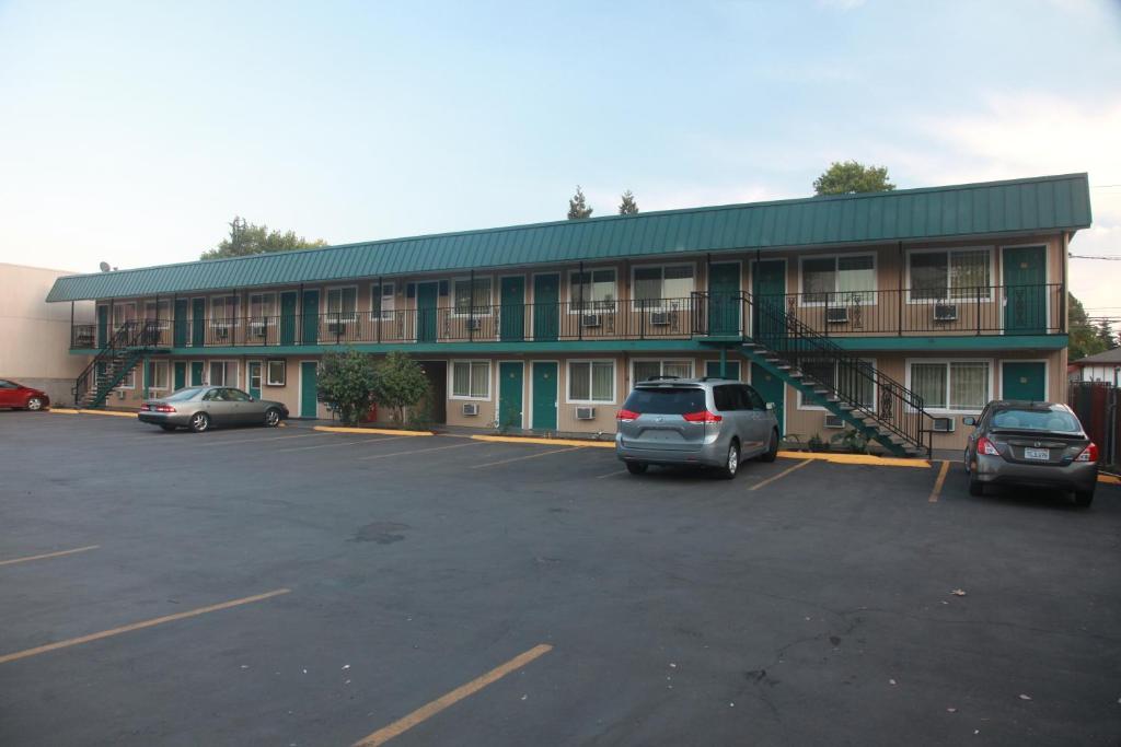 un edificio con coches estacionados en un estacionamiento en Executive Motel, en Eugene
