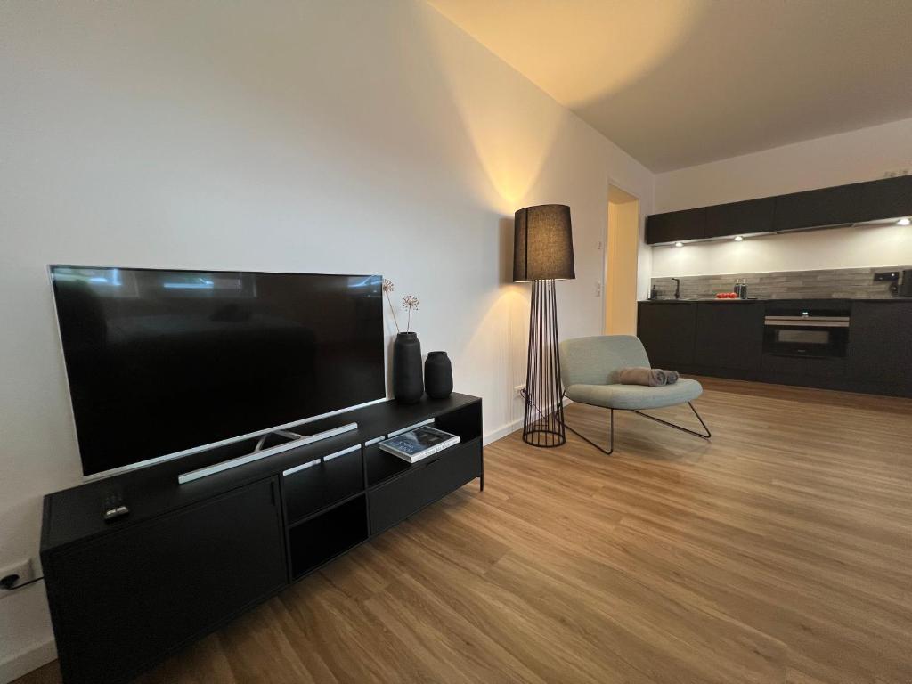 sala de estar con TV de pantalla plana grande en Apartmenthaus Stade Schwingewiesen Apartment 6, en Stade