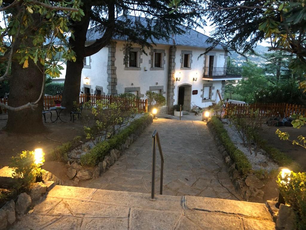 Biały dom z oświetleniem przed nim w obiekcie EL MOTIVO w mieście Cercedilla
