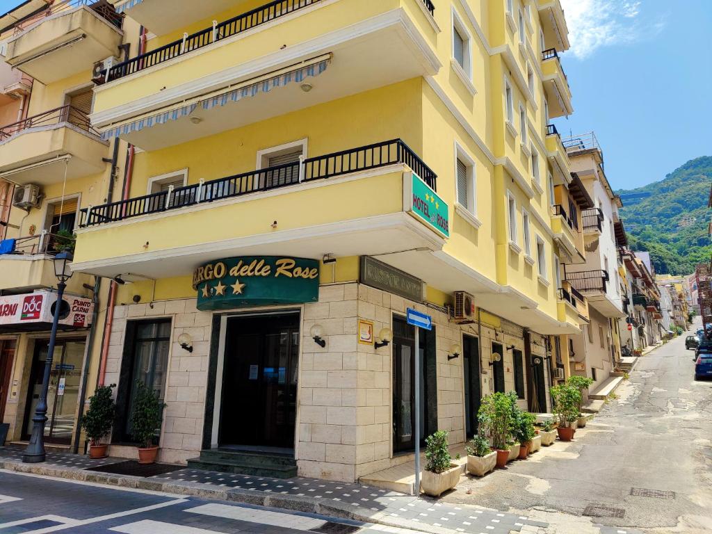 un edificio amarillo con un cartel en una calle en Albergo delle Rose, en Bagnara Calabra