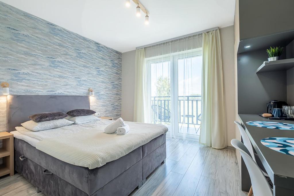 a bedroom with a bed with a brick wall at Jakubowa Polana - apartamenty i pokoje in Łeba