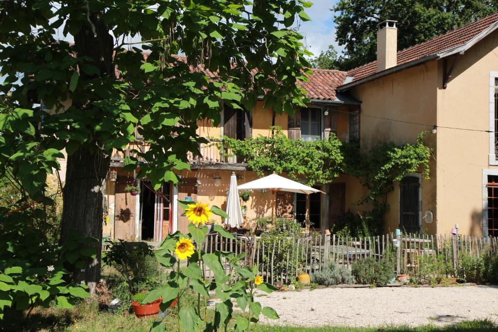 a house with a fence and a sunflower at souslens in Castaignos-Souslens