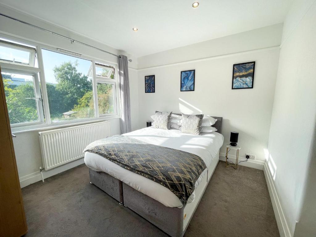 a bedroom with a bed and two windows at Central Chelmsford Apartment with Garden in Chelmsford