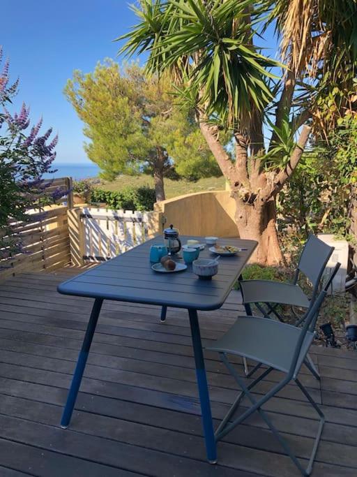 a blue table and two chairs on a deck at LE CAP - bungalow vue mer et colline - Hauteur de Cassis in Cassis