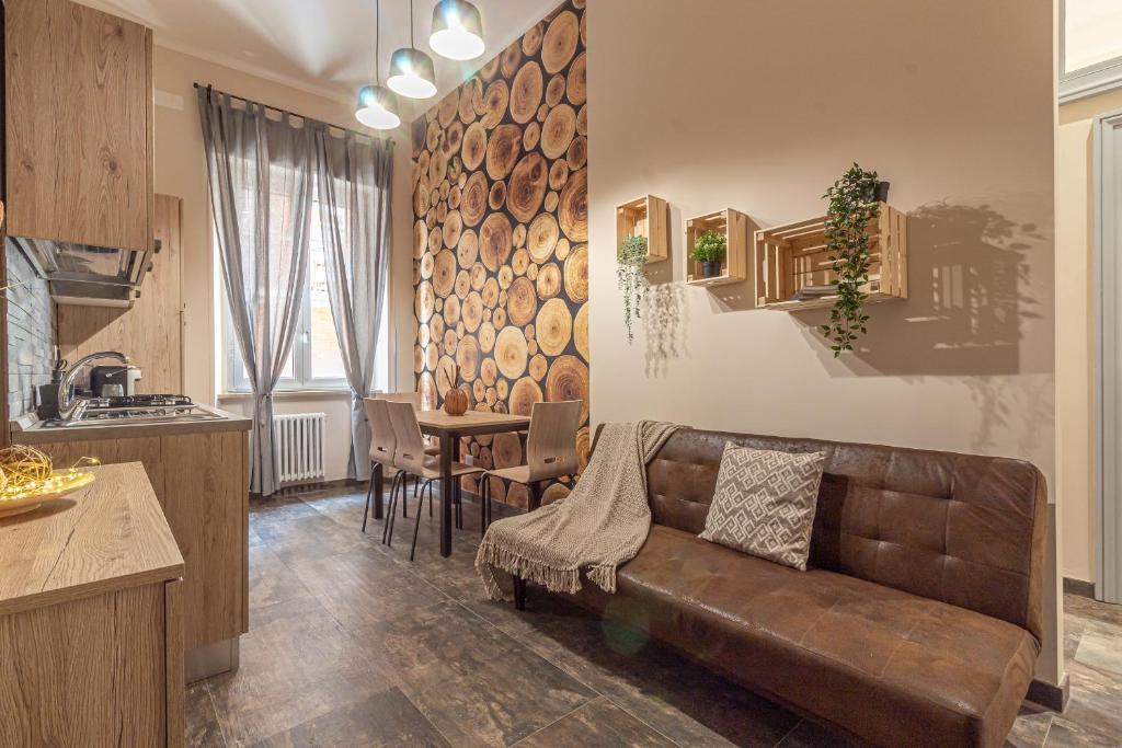 een woonkamer met een bruine bank en een keuken bij Galvani Apartments in Terni