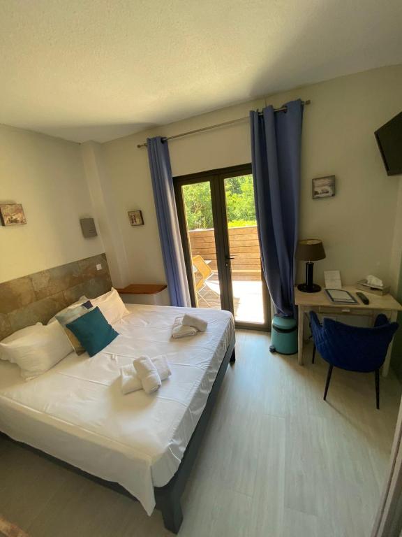 a bedroom with a bed and a desk and a window at Le Belvedere in Vallon-Pont-dʼArc