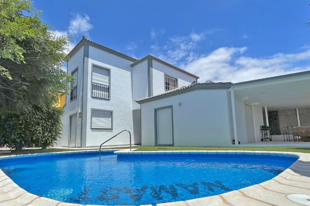 a swimming pool in front of a house at Villa Namaste in Adeje