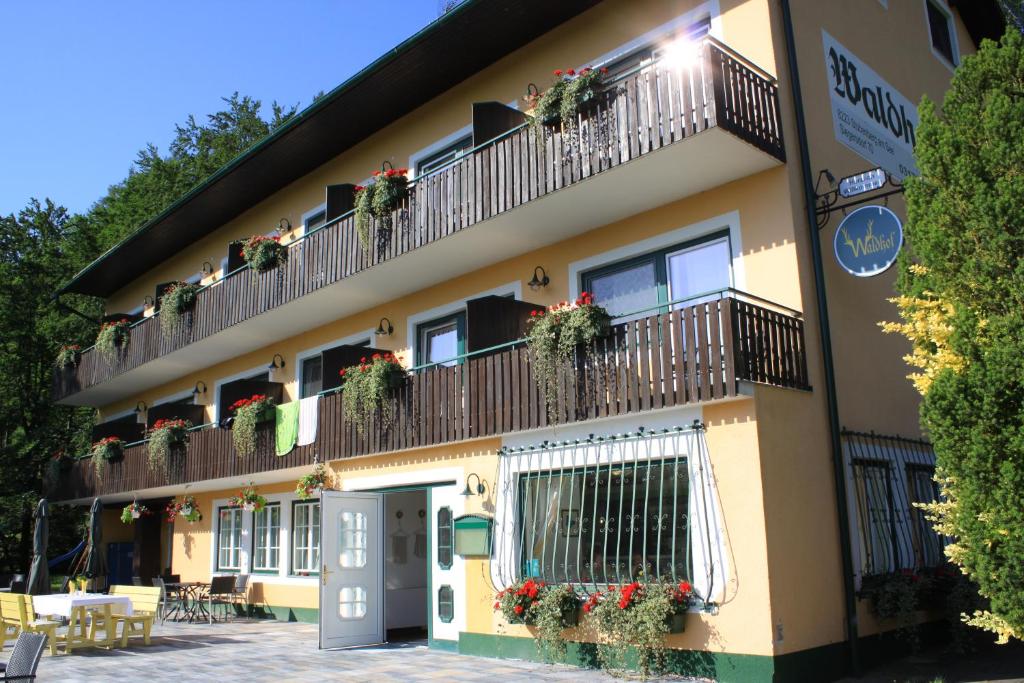- un bâtiment avec des balcons fleuris dans l'établissement Pension Waldhof am Stubenbergsee, à Stubenberg