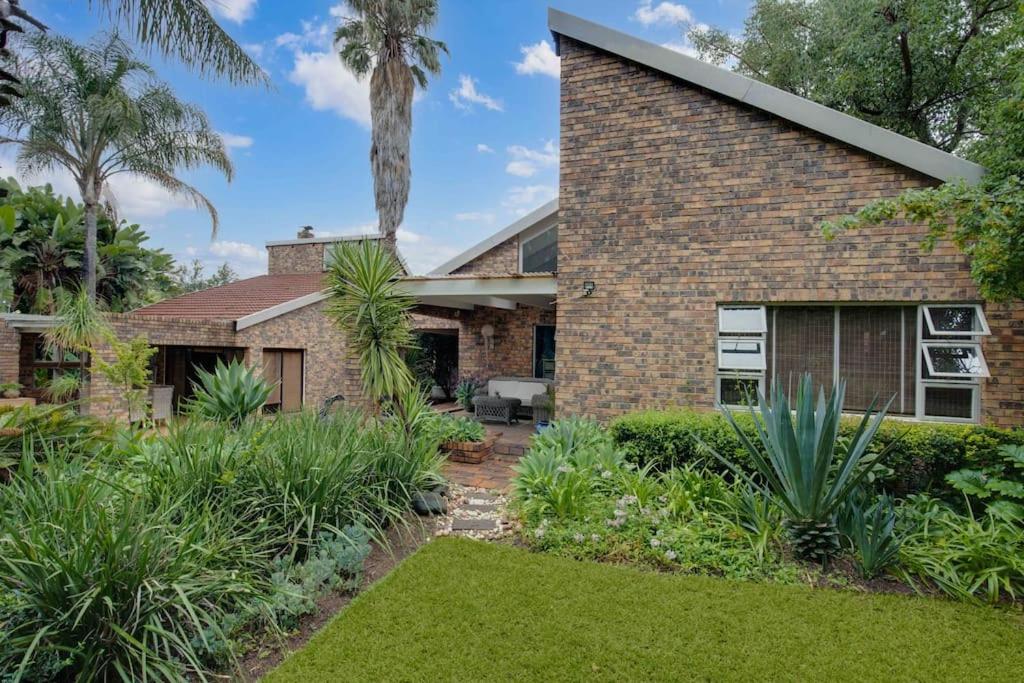 a brick house with a garden in front of it at The House Fourways in Sandton