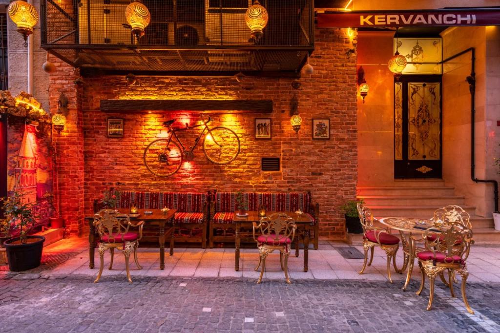 a restaurant with tables and chairs in front of a brick wall at Kervanchi in Istanbul