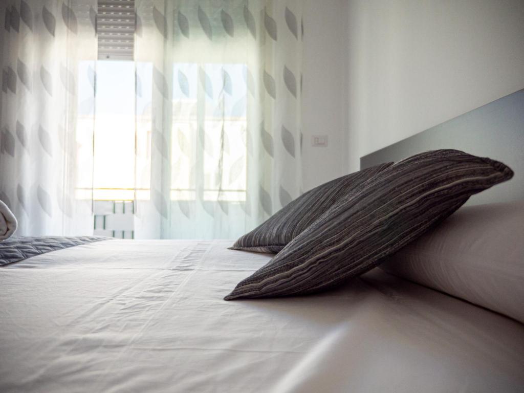 a pillow sitting on a bed with a window at biRose B&B Affittacamere in Otranto