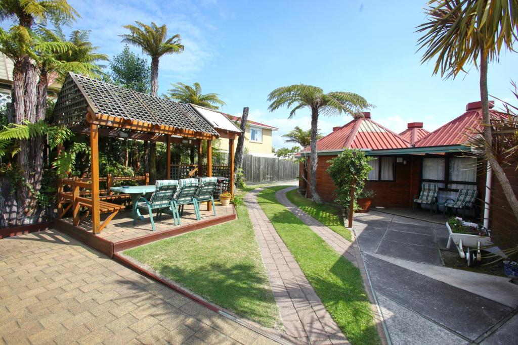 een huis met een patio met een tafel en stoelen bij Pure Motel in Rotorua