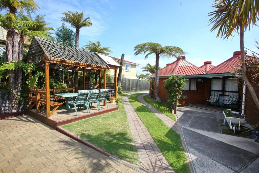 a house with a patio with a table and chairs at Pure Motel in Rotorua