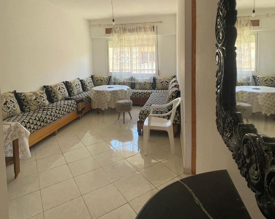 uma sala de estar com um sofá, mesas e um espelho em PROMO Appartement Familial avec WiFi em Al Hoceïma
