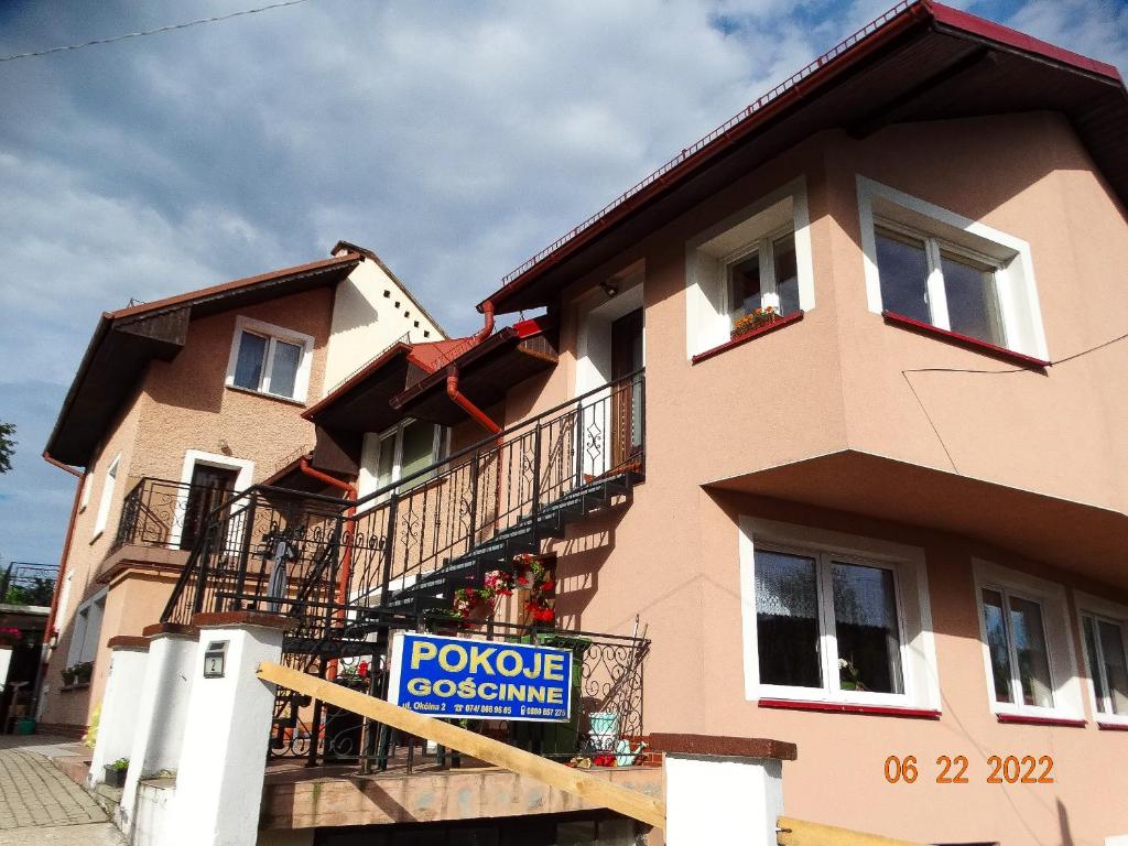 a large house with a sign in front of it at Pokoje Gościnne in Duszniki Zdrój