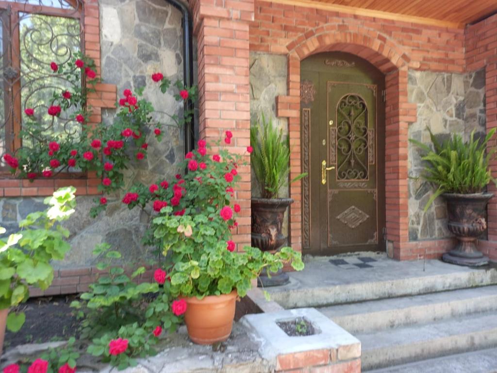 a front door of a house with flowers and plants at Yurd in Sheki in Sheki