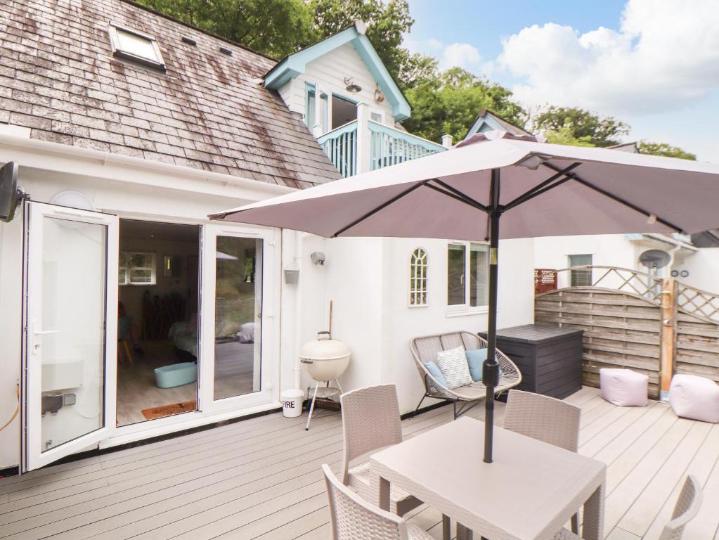 a patio with a table and an umbrella at Penpoll in Wadebridge