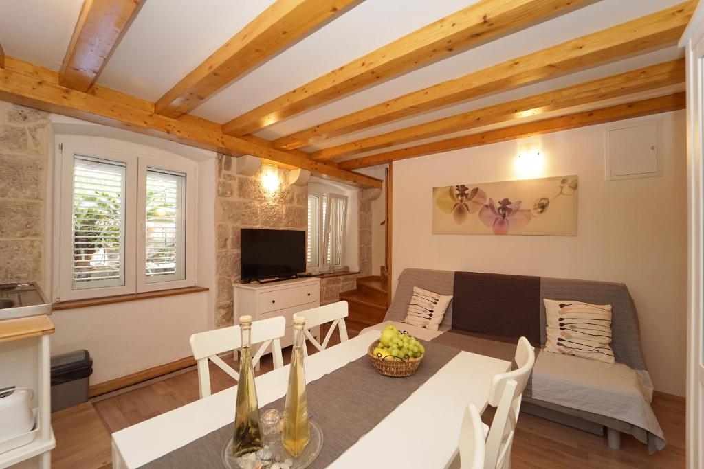 ein Wohnzimmer mit einem Tisch und einem Sofa in der Unterkunft Confluence Apartments in Korčula