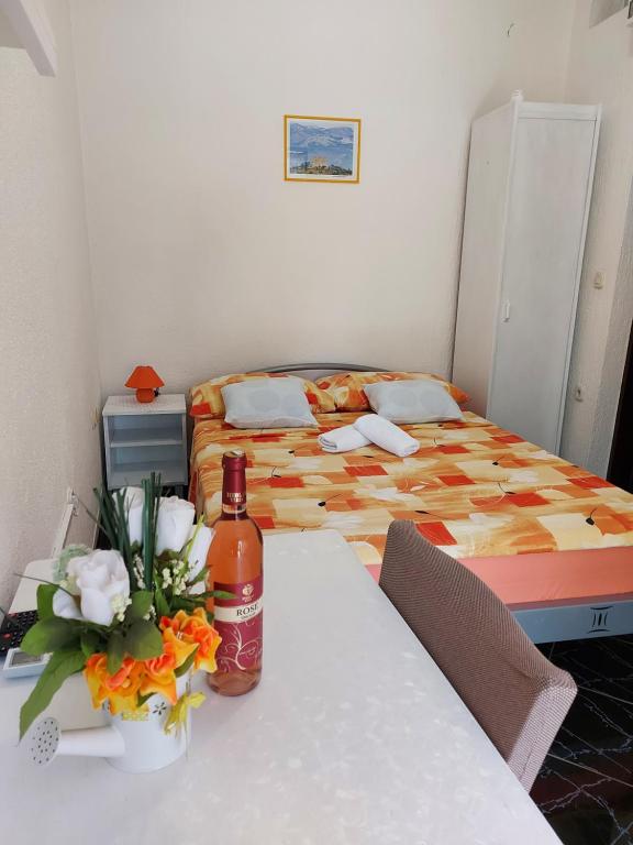 a bedroom with a bed and a table with a bottle of wine at Dalibor in Senj