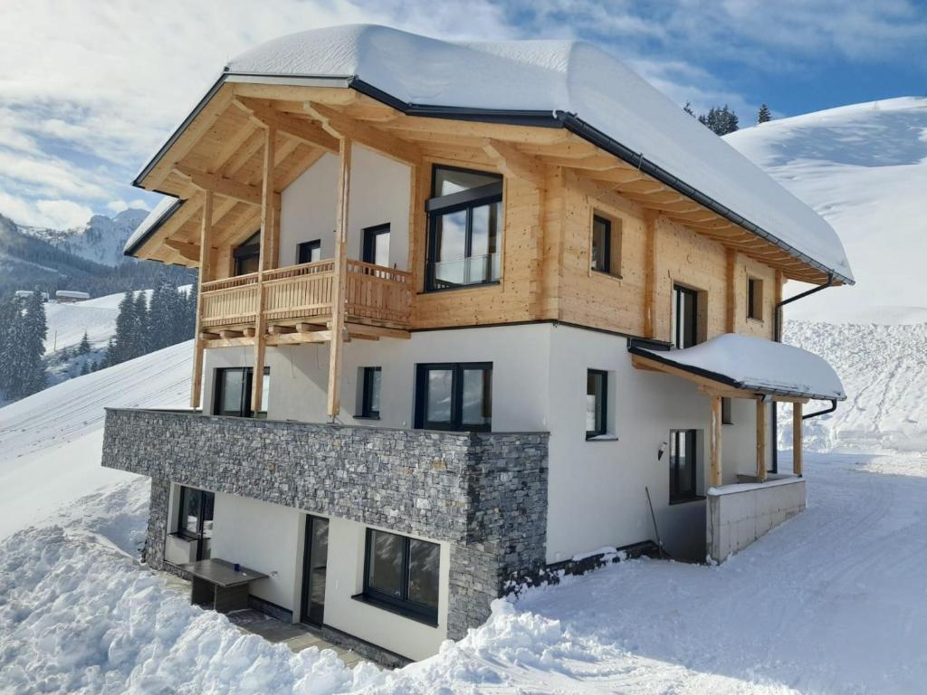 a house on top of a snow covered mountain at Appartement Kuschelzeit Jansenbichl in Wagrain