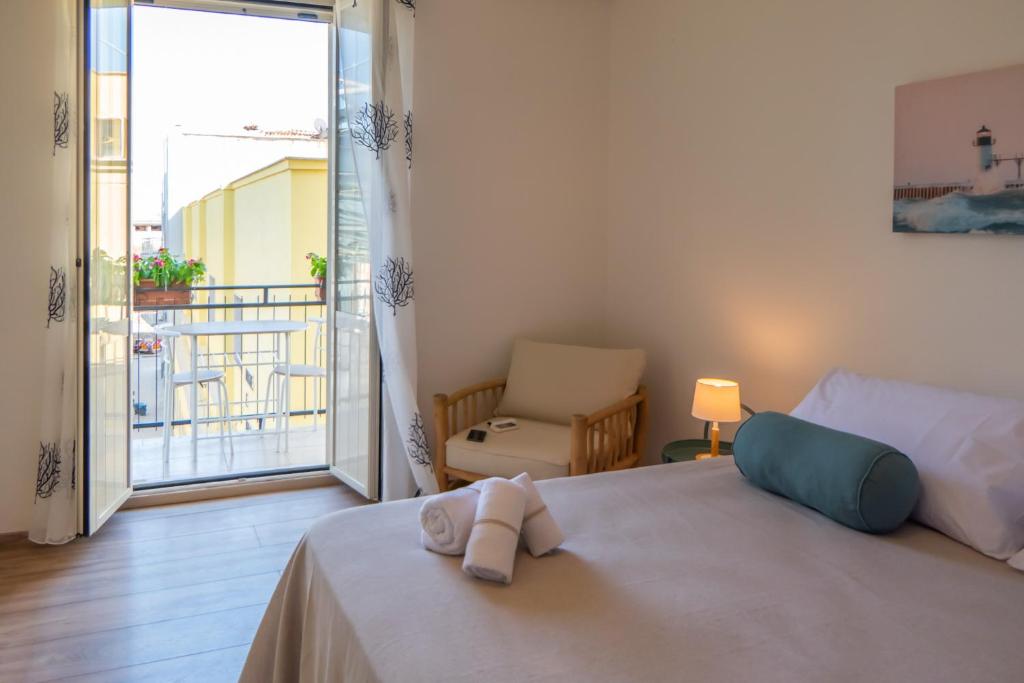 a bedroom with a bed and a view of a balcony at Biggy Apartment in Olbia