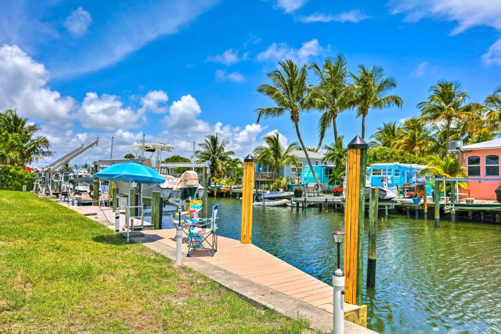 un port de plaisance dans un complexe avec des palmiers dans l'établissement Jensen Beach Home with Private Dock and Ocean Access!, à Jensen Beach