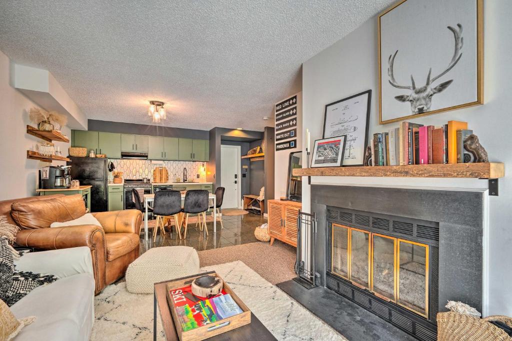 a living room with a fireplace and a kitchen at Ski-InandSki-Out Magic Mountain Condo with Deck! in Londonderry