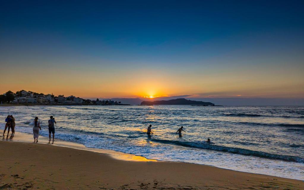 people playing in the water at the beach at sunset at Zinovia in Kato Daratso