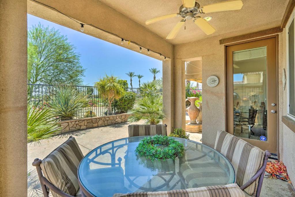 un patio con mesa de cristal y sillas en Sunny Palm Desert Home - Swim, Golf and Relax! en Palm Desert
