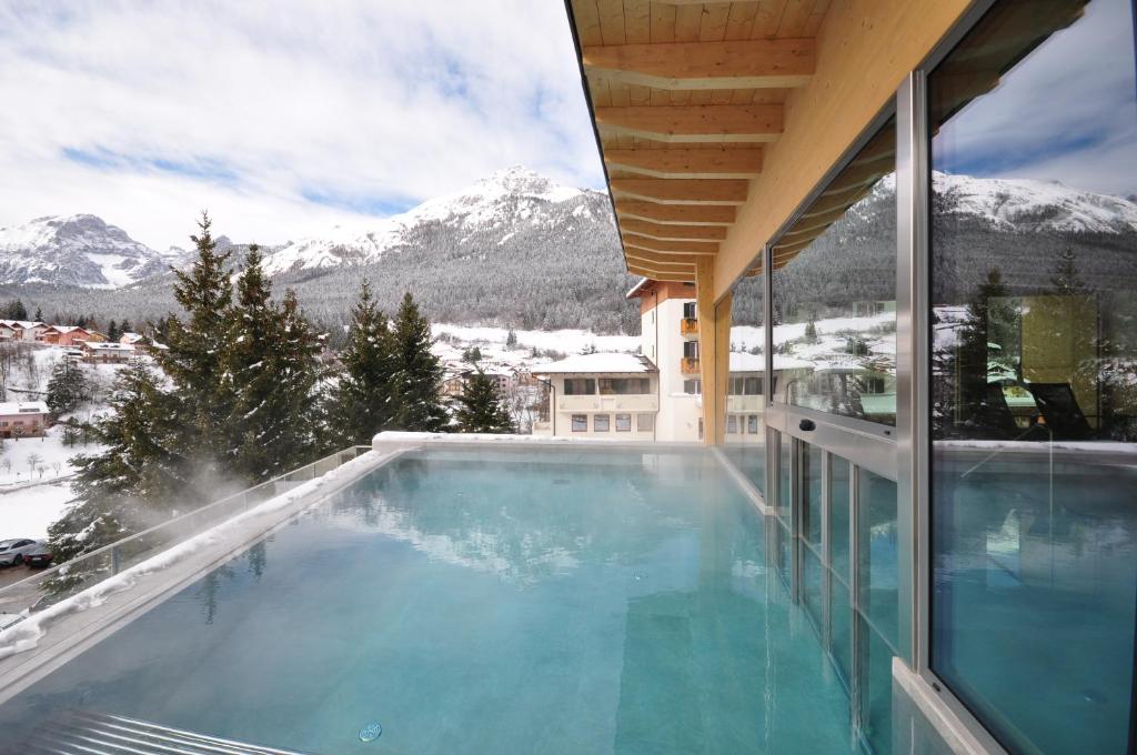 una piscina con vistas a las montañas cubiertas de nieve en Hotel Select en Andalo