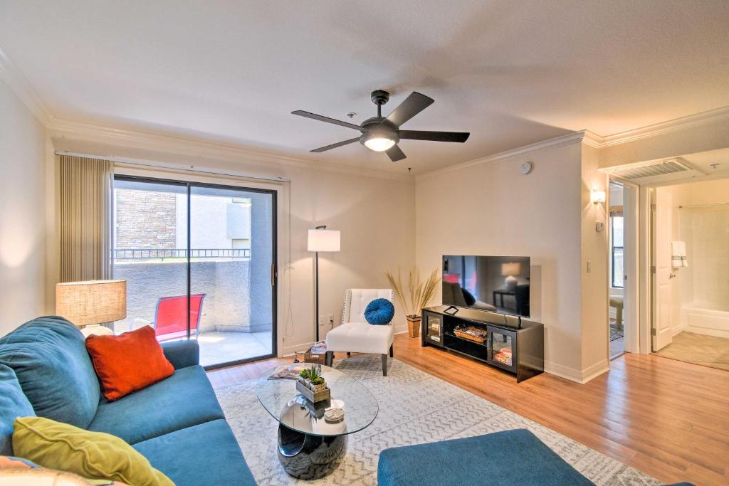 a living room with a blue couch and a ceiling fan at 6 Mi to Downtown Phoenix Condo with Pool Access! in Phoenix