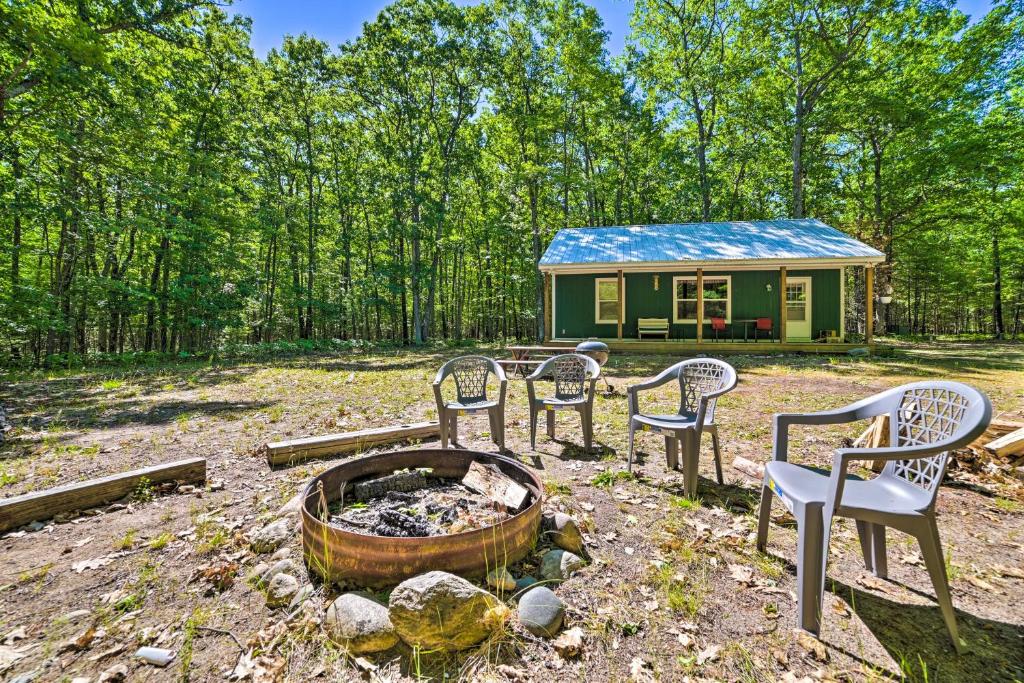 a group of chairs and a fire pit in front of a tiny house at Secluded Indian River Retreat with Fire Pit! in Indian River