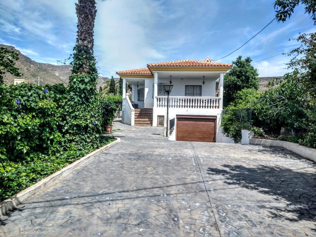 una casa blanca con una entrada delante de ella en Chalet con piscina en Níjar, en Níjar
