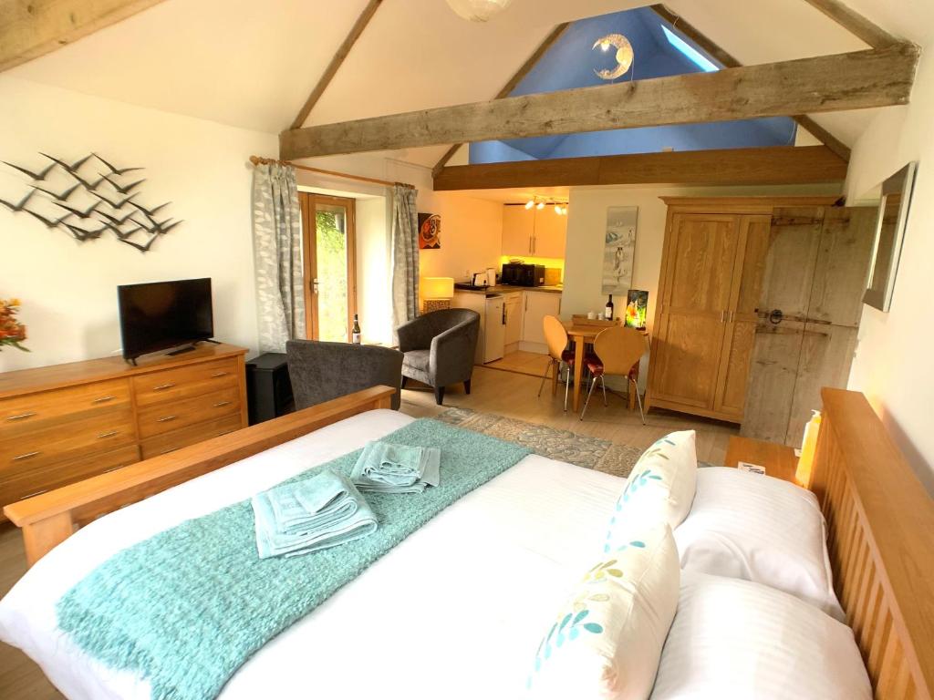 a bedroom with a bed and a living room at A Delightful Barn in a Peaceful and Private Setting, Close to Dartmoor and the Beautiful Tamar Valley in Gunnislake