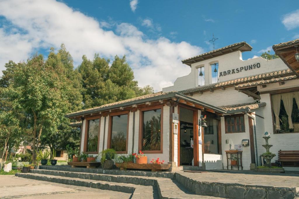 un edificio con un banco delante de él en Hotel Hacienda Abraspungo, en Riobamba