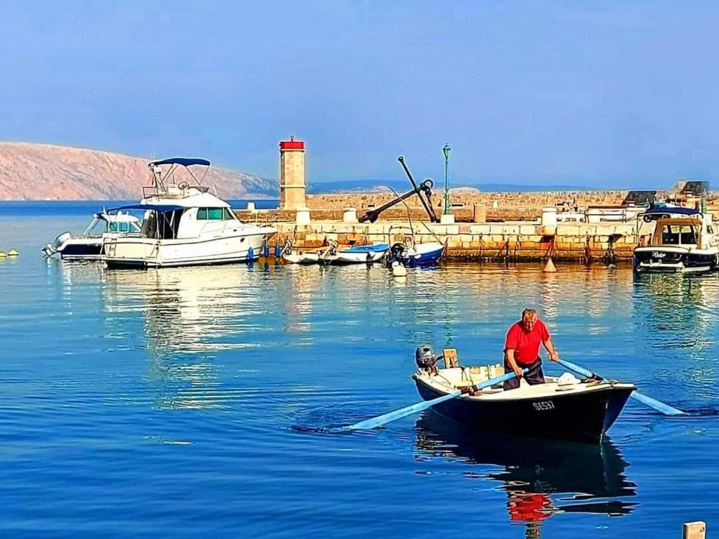 a man is rowing a boat in the water at Dalibor in Senj