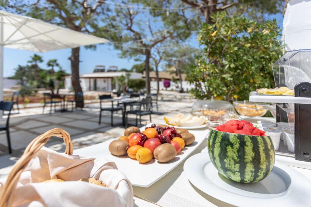 a table with plates of fruit and a bowl of watermelon at B&B Villa Massimo in Porto Cesareo