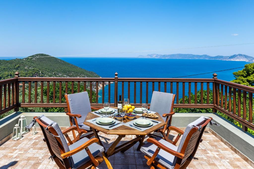 a table and chairs on a balcony with a view of the ocean at Villa Margini, Aegean Views , Pool Villa, Skopelos in Skopelos Town