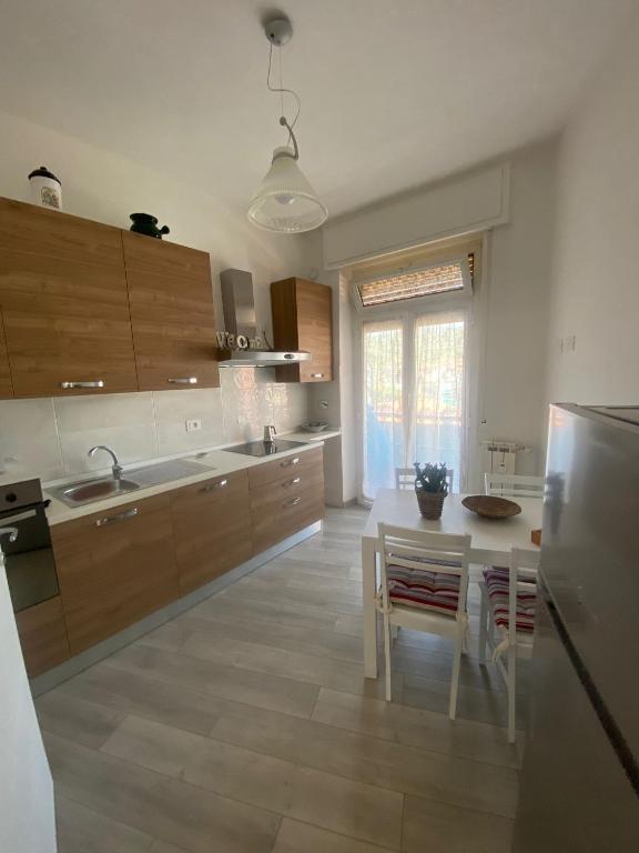 kuchnia z drewnianymi szafkami, stołem i zlewem w obiekcie Casa Belinda w mieście La Spezia