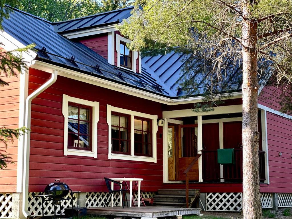 a red house with a table in front of it at Villa Talvitahko 5 in Tahkovuori