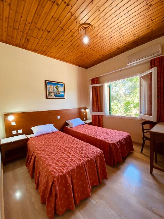 a hotel room with two beds and a window at Beach House in Lefkimmi