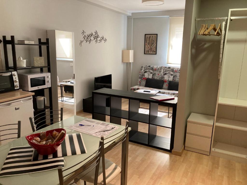 Hotel Hs Rincón de Sito 7 Suite Center City Total Equipado, a kitchen and a living room with a table and chairs at Hs Rincón de Sito 7 Suite Center City Total Equipado in Salamanca