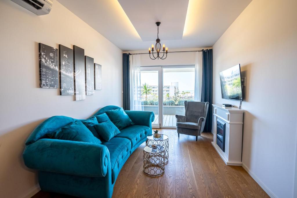 a living room with a blue couch and a chair at Morska vila 6 Luxury Apartment Žnjan in Split