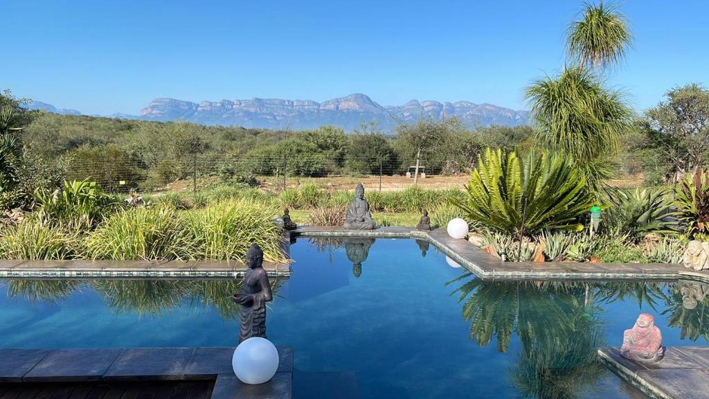 ein Wasserbad mit Statuen in einem Garten in der Unterkunft hippomoon lodge game reserve in Hoedspruit