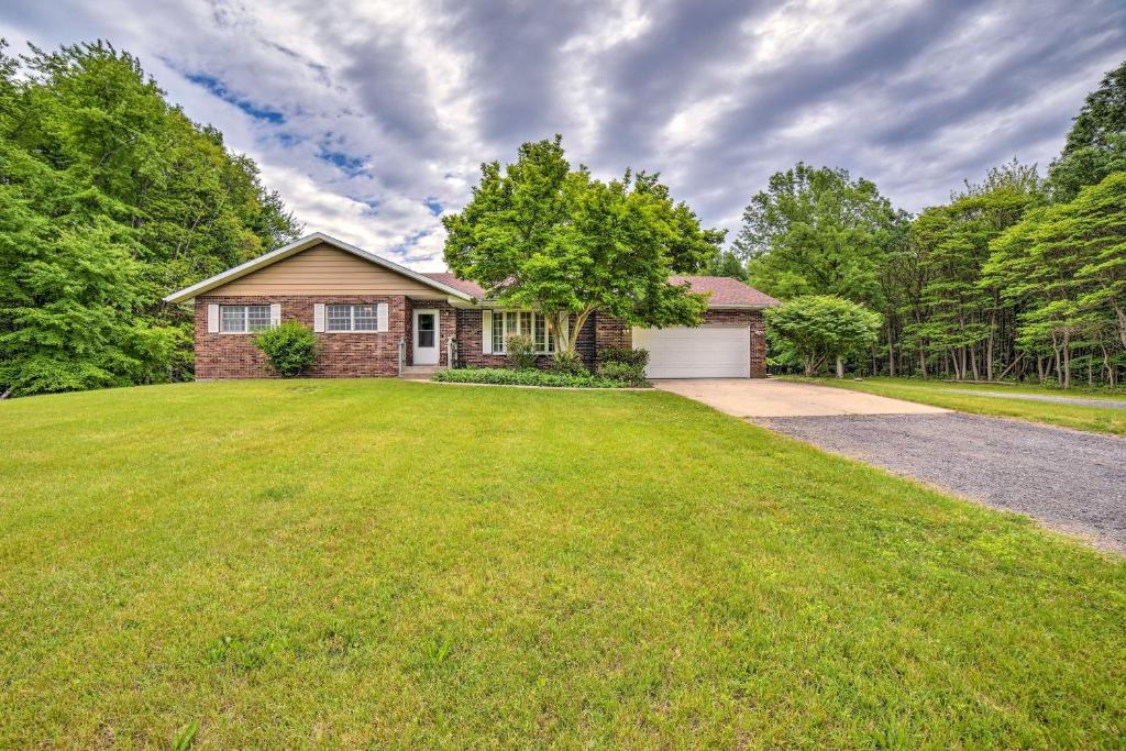 ein Backsteinhaus mit einer Garage auf einem Rasenplatz in der Unterkunft Indiana Countryside Retreat on 37-Acre Land! in Michigan City