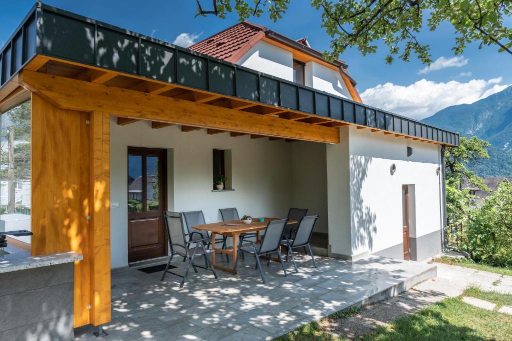 a patio with a table and chairs on top of a house at House Hiperbola & Outdoor Activities in Bovec