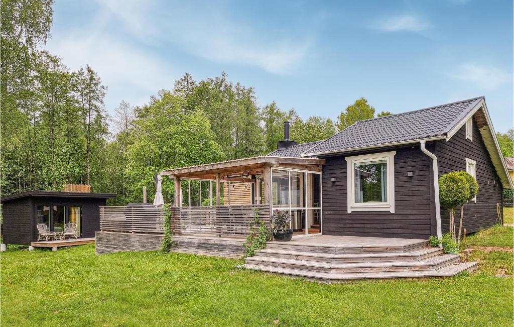 a black house with a porch and a yard at Gorgeous Home In Hkerum With Lake View in Hökerum