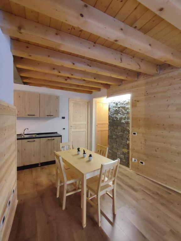 a kitchen with a table and chairs in a room at Appartamento sul Ruscello in Ponte di Legno