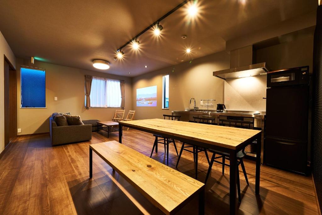 un soggiorno con tavoli in legno e una cucina di Rakuten STAY HOUSE Kisarazu a Kisarazu