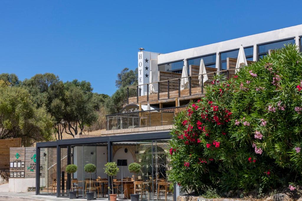 a building with tables and chairs in front of it at Auberge Kallisté - Eco Label in Porto Pollo